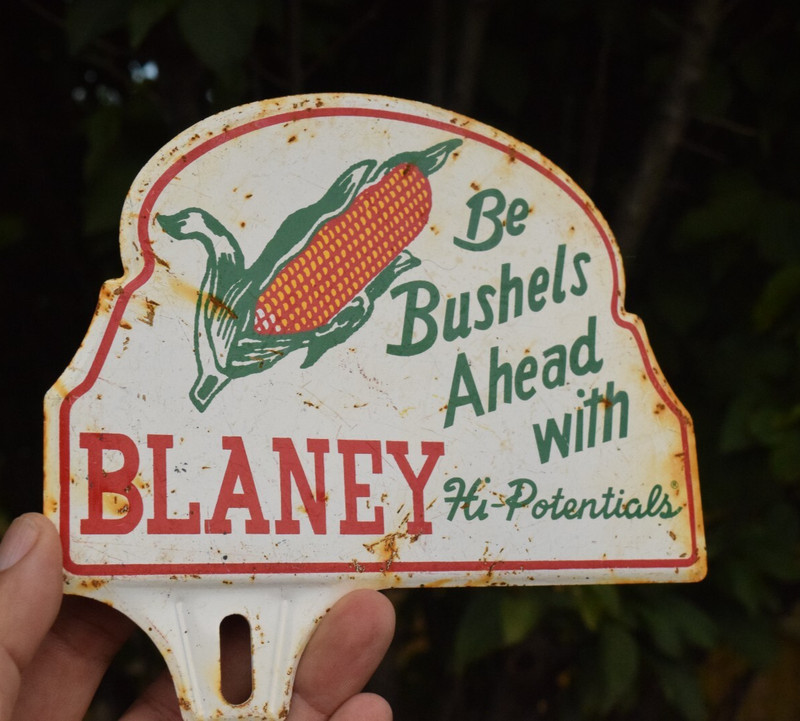 1950s BUSHELS AHEAD WITH BLANEY STAMPED PAINTED METAL TOPPER SIGN SEED FEED CORN